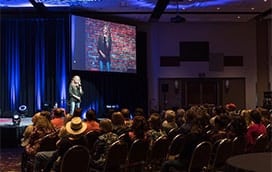 Megan Bryant doing standup comedy in front of a large crowd
